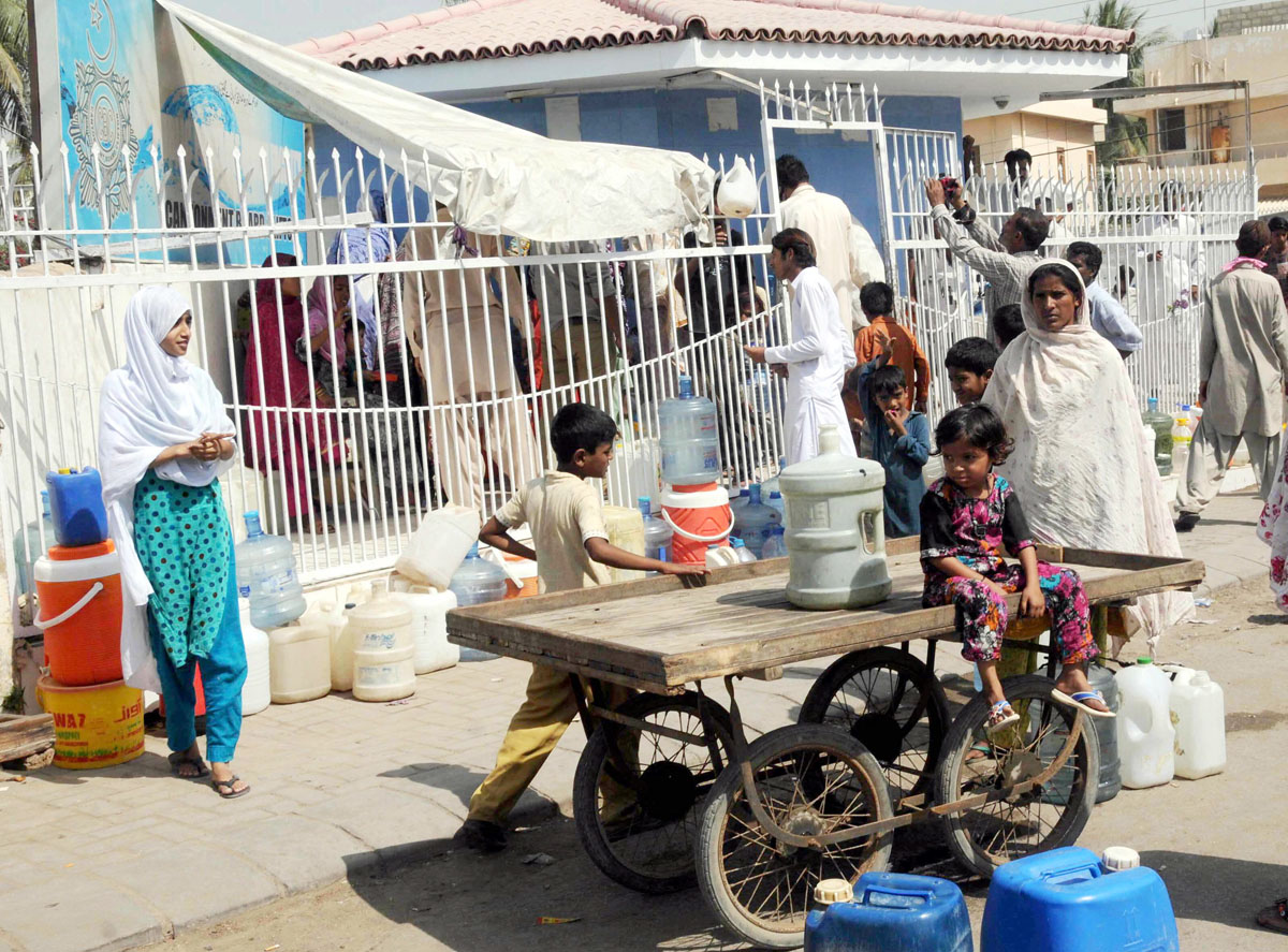 people line up to fill water cans from a filling station in karachi after the city was hit with water shortages photo mohammad azeem express