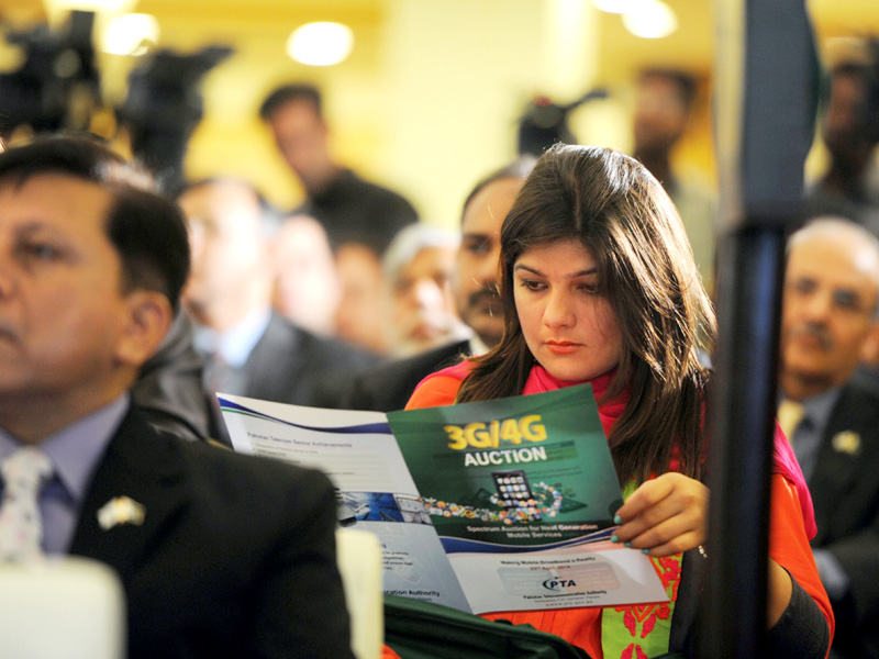 a woman reads a brochure of 3g and 4g of next generation telecommunications during an auction in islamabad photo afp