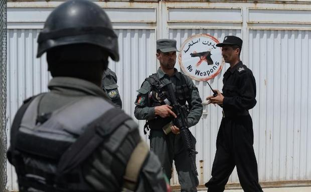 afghan police stand guard at the gate of the cure international hospital in kabul on april 24 2014 after a gunman killed three americans photo afp