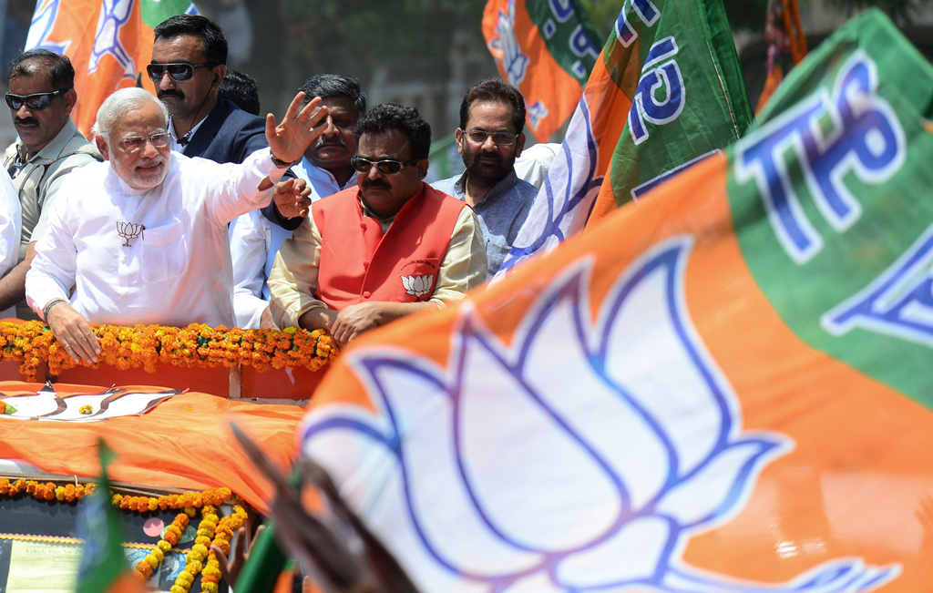 india 039 s main opposition bharatiya janata party bjp prime ministerial candidate and chief minister of the western indian state of gujarat narendra modi l waves to supporters as he arrives to file his election nomination papers in varanasi on april 24 2014 photo afp