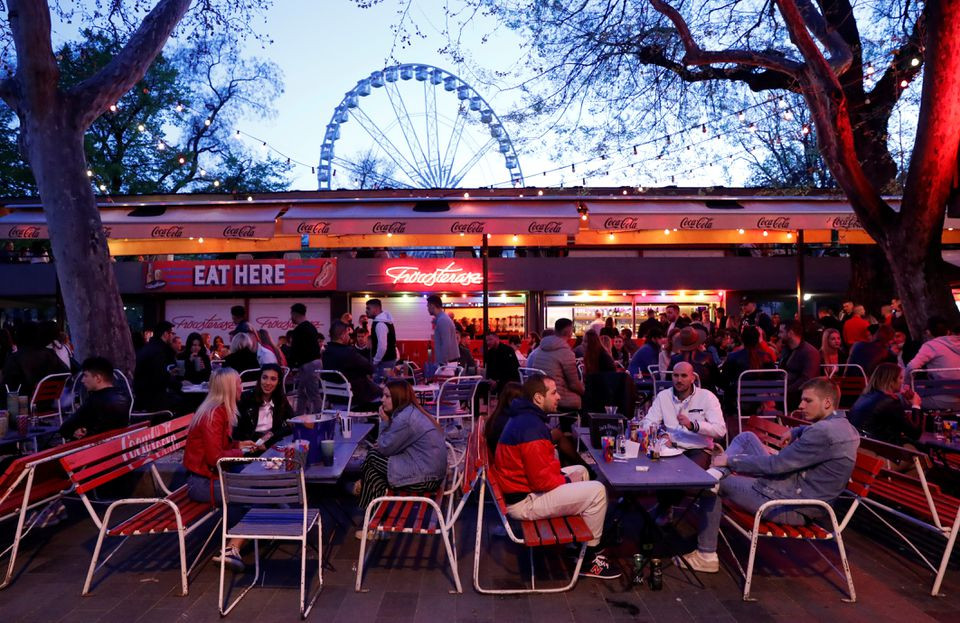 people enjoy the evening in front of a bar after the hungarian government allowed the reopening of outdoor terraces as the spread of the coronavirus disease covid 19 continues in budapest hungary photo reuters