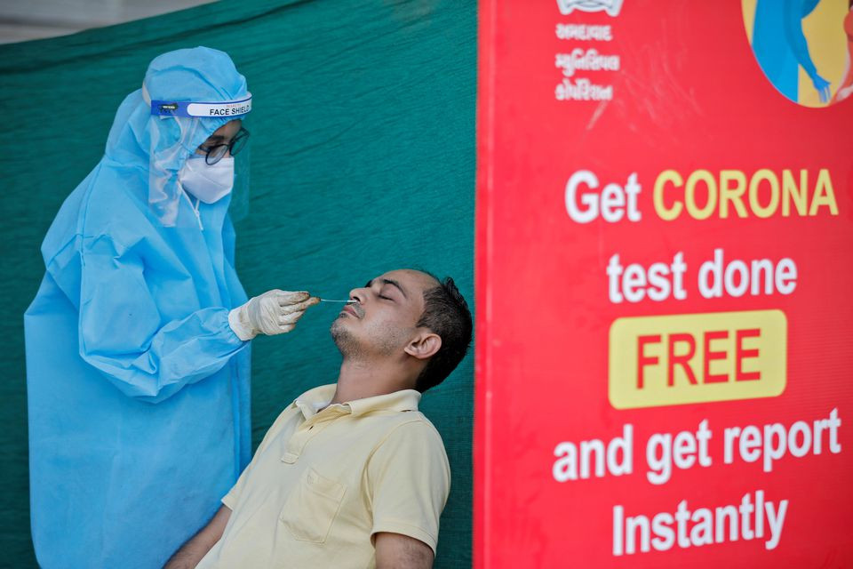 a healthcare worker wearing personal protective equipment ppe takes swab from a man during a testing campaign for the coronavirus disease covid 19 in ahmedabad india november 24 2020 reuters
