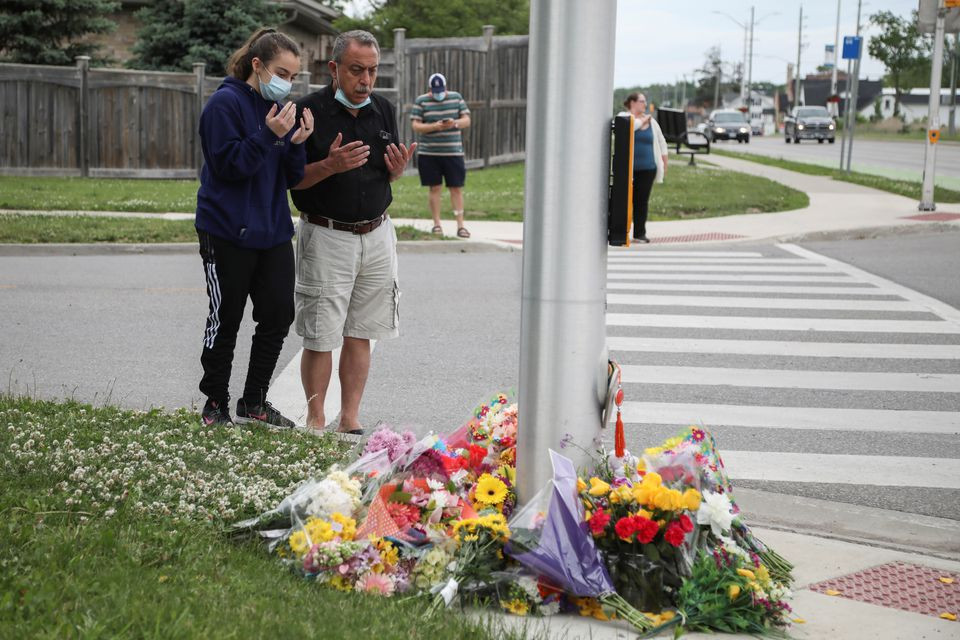 abdullah alzureiqi and his daughter hala say a prayer at the fatal crime scene where a man driving a pickup truck jumped the curb and ran over a muslim family in what police say was a deliberately targeted anti islamic hate crime in london ontario canada june 7 2021 photo reuters