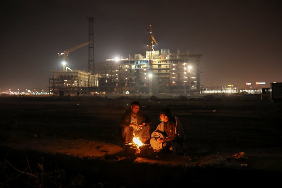 Migrants warm themselves by the fire outside a derelict customs warehouse in Belgrade, Serbia. PHOTO: REUTERS