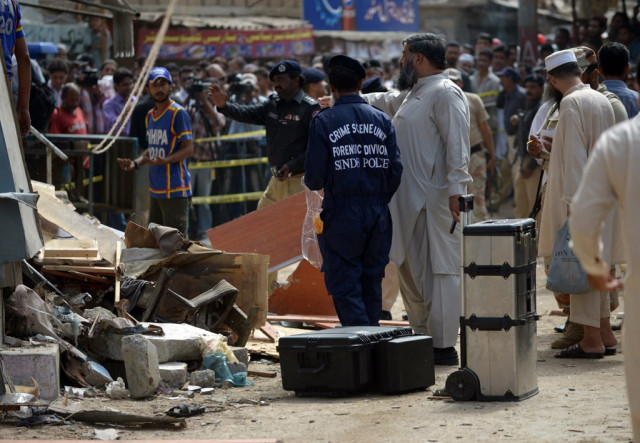 security officials inspecting the site of a bomb attack to collect evidence in karachi on april 24 2014 photo afp security officials inspecting the site of a bomb attack to collect evidence in karachi on april 24 2014 photo afp