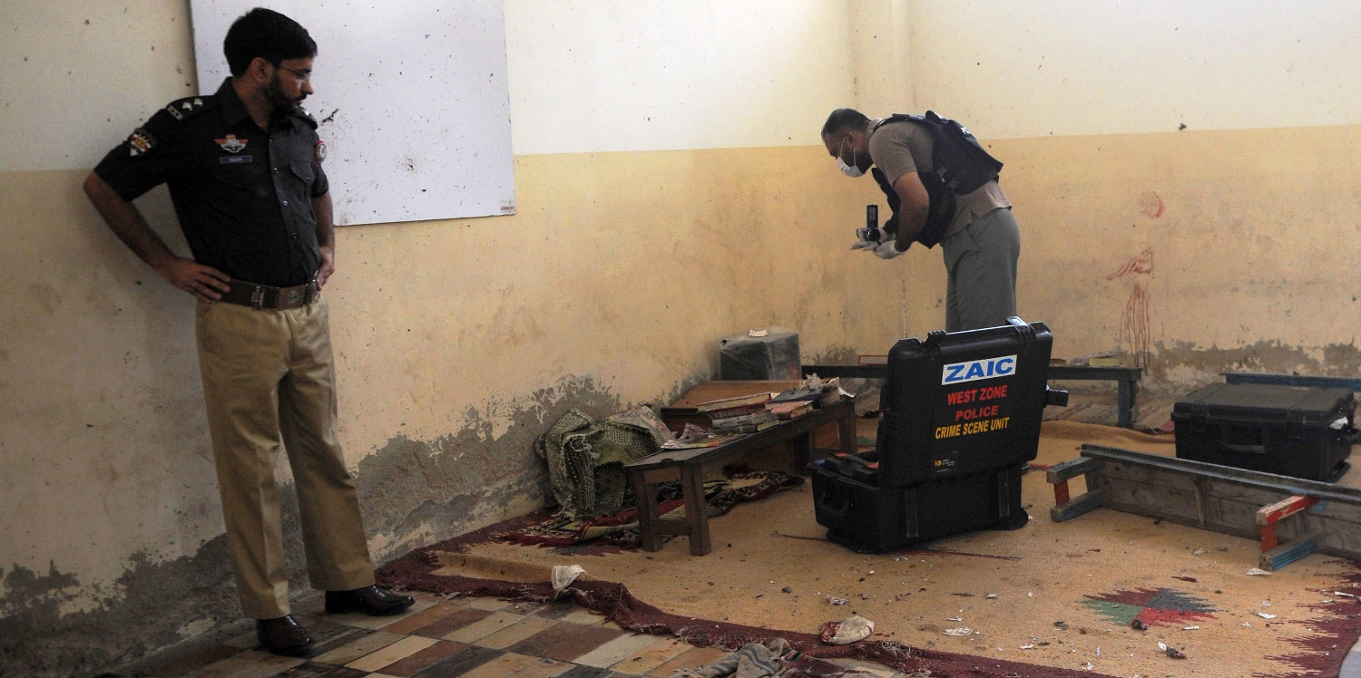 pakistani forensic experts collect evidence at a religious seminary after a bomb attack in karachi on april 28 2014 a blast killed three boys aged between 10 and 12 at a religious seminary in the southern pakistani city of karachi police said photo afp