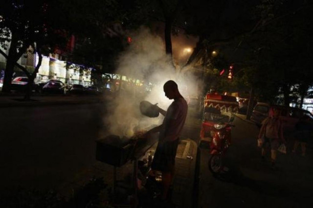 a man fans a grill while cooking kebabs at a roadside stall in central beijing photo reuters a man fans a grill while cooking kebabs at a roadside stall in central beijing photo reuters
