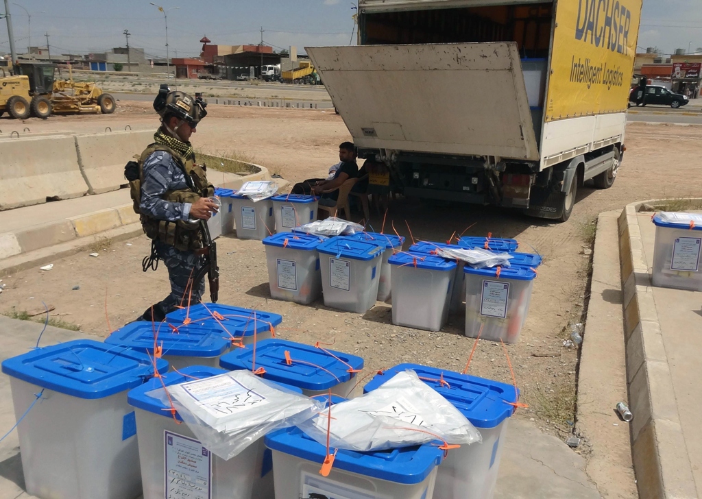 a member of the iraqi security forces stands near ballot boxes as officials prepare to count votes at a polling station photo afp