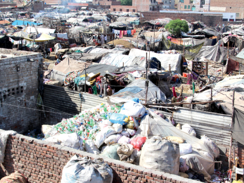 a view of a squatter settlement from above reveals heaps of sorted and semi sorted recyclable materials massive piles of plastic bottles and cardboard boxes are a common sight used clothes are washed and hung on wires crisscrossing the area photo zehra hashmi express