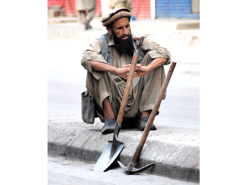 a day labourer sits in wait hoping someone will hire his services photo app