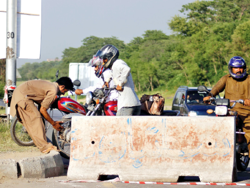 biker being helped to jump the divider to save time photo muhammad javaid express