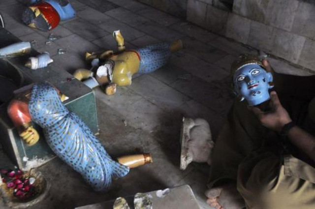 a member of the hindu community holds a damaged statue inside a temple that was attacked in larkana in sindh photo reuters a member of the hindu community holds a damaged statue inside a temple that was attacked in larkana in sindh photo reuters