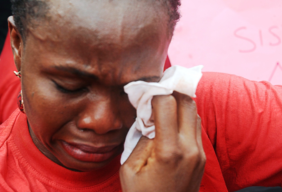 one of the mothers of the missing chibok school girls wipes her tears as she cries during a rally by civil society groups pressing for the release of the girls in abuja on may 6 2014 ahead of world economic forum photo afp