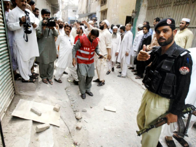 police and rescue workers stand at the site of the blast which left three children injured photo inp police and rescue workers stand at the site of the blast which left three children injured photo inp