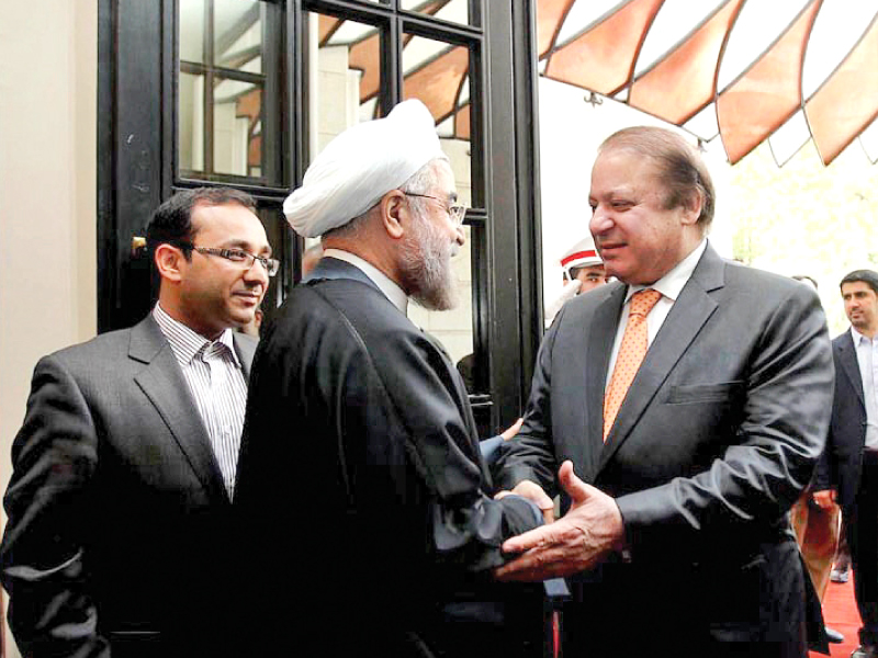 a handout picture released by iran shows president hasan rowhani welcomes pm nawaz sharif prior to their meeting photo inp
