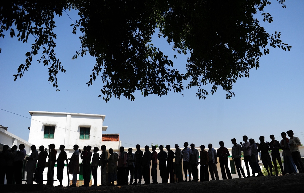 indian voters wait to cast their ballots at a polling station in azamgarh photo afp