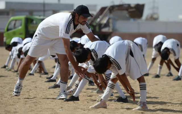 academy coach mohsin shah l instructs local youth as they participate in a training session at a local stadium in karachi photo afp academy coach mohsin shah l instructs local youth as they participate in a training session at a local stadium in karachi photo afp
