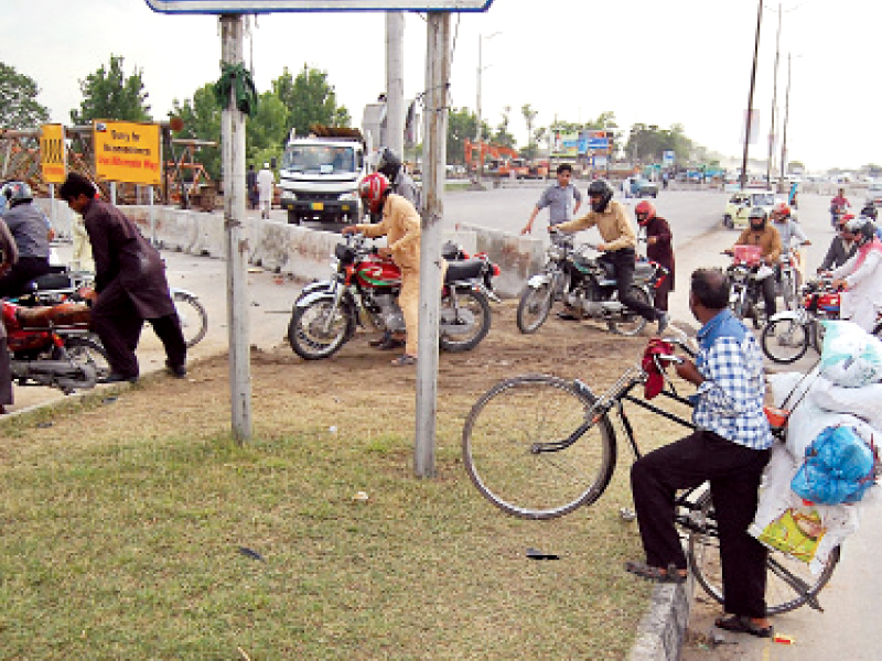 motorcyclists crossing the divider after getting to section of kashmir highway which has been blocked off photo muhammad javaid express