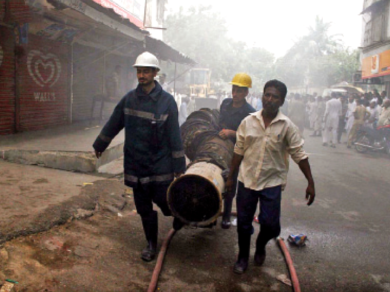 firefighters remove debris from the garment factory that was gutted by fire on thursday morning the biggest obstacle for the firefighters was getting close to the fire as there was no clear path leading to the basement where the factory was located photo online