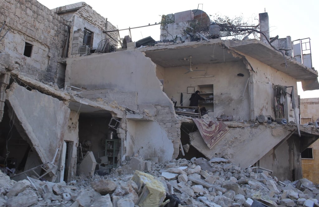 a woman inspects her damaged home in aleppo december 15 2013 photo reuters