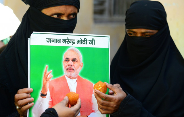 indian muslim women hold up sweets and a portrait of victorious bharatiya janata party bjp prime ministerial candidate narendra modi in varanasi on may 16 2014 photo afp indian muslim women hold up sweets and a portrait of victorious bharatiya janata party bjp prime ministerial candidate narendra modi in varanasi on may 16 2014 photo afp