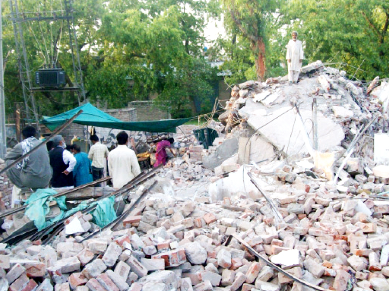 residents sit on piles of rubble that were their houses a few hours earlier photo rana tanveer express