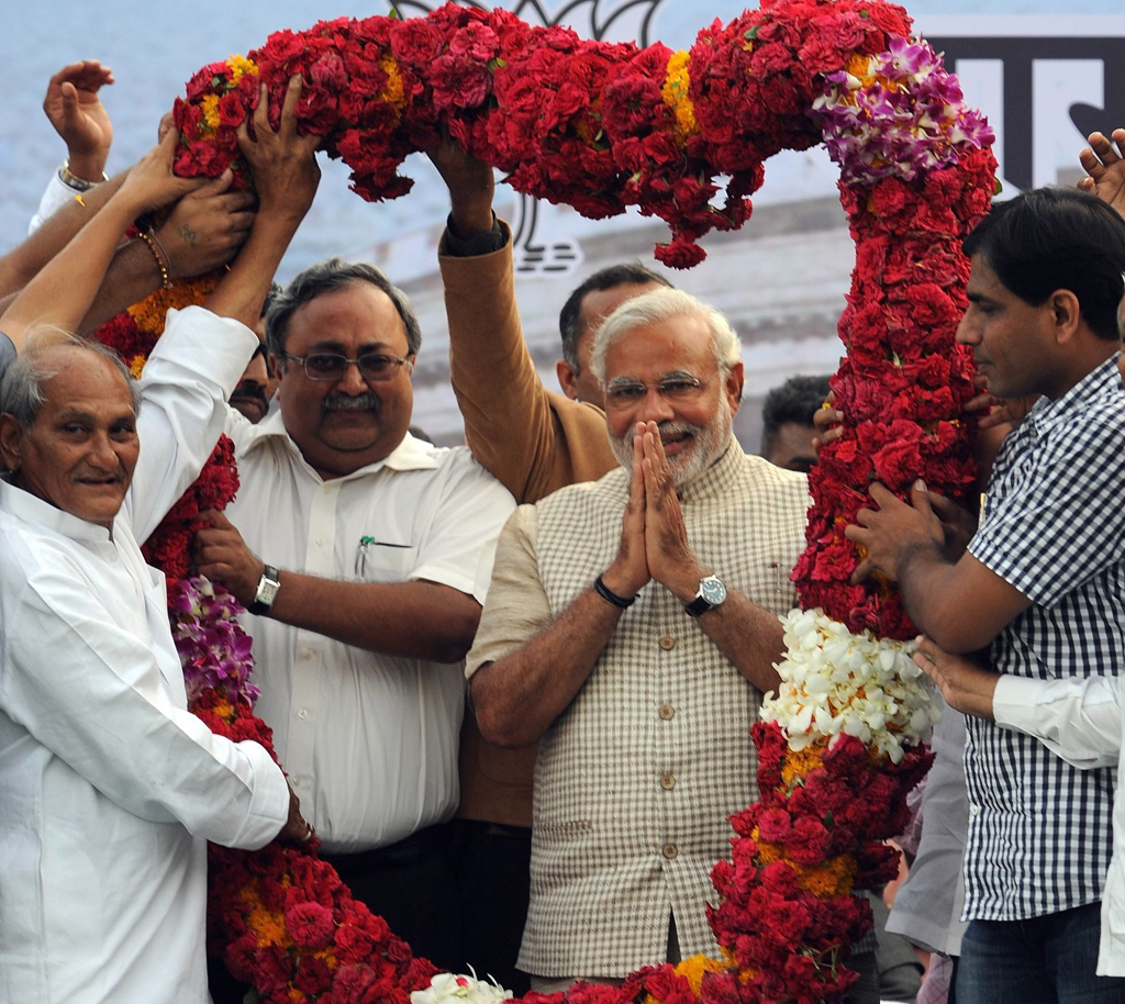 chief minister of western gujarat state and main opposition bharatiya janata party bjp prime ministerial candidate narendra modi 2nd r is garlanded as he arrives at a public rally after his victory in vadodara on may 16 2014 photo afp