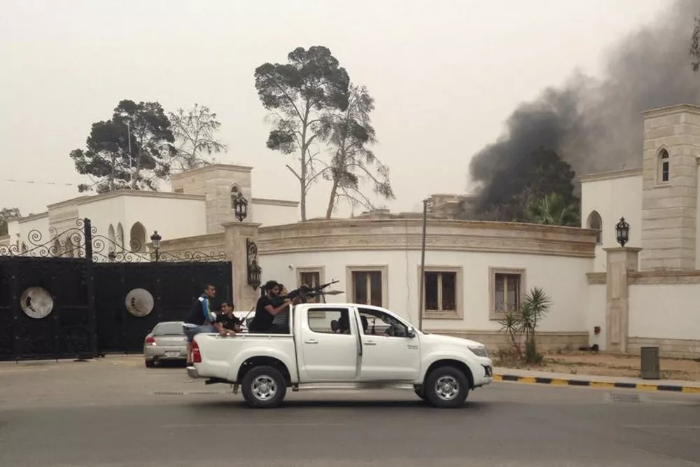 armed men aim their weapons from a vehicle as smoke rises in the background near the general national congress in tripoli photo reuters armed men aim their weapons from a vehicle as smoke rises in the background near the general national congress in tripoli photo reuters