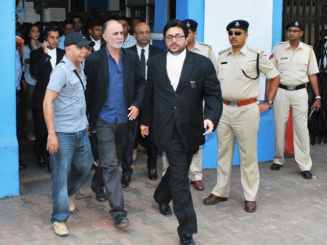 former indian magazine editor tarun tejpal c is escorted by officials as he leaves a session court in panaji on november 30 2013 photo afp