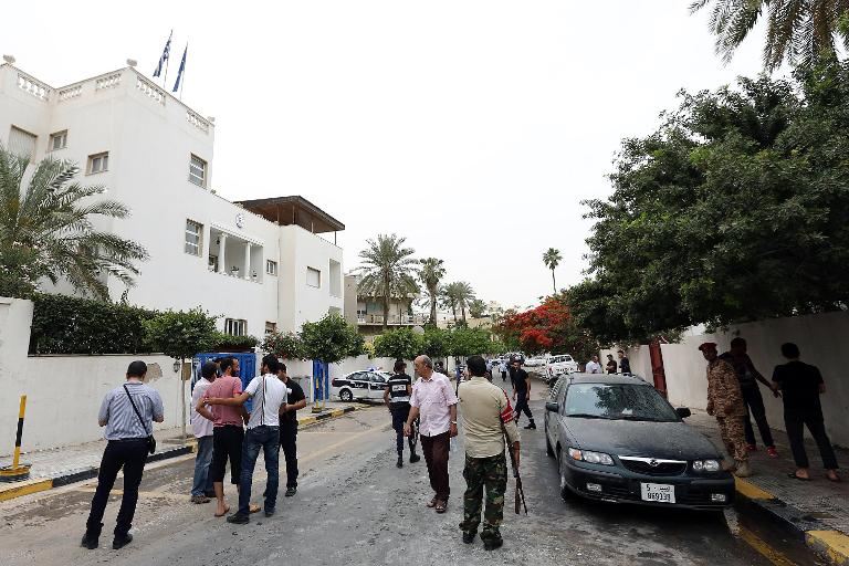 security forces and residents gather in the tripoli street housing the saudi embassy on may 18 2013 following a bomb blast photo afp