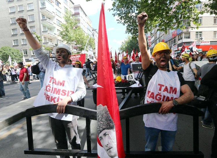 protesters wearing hard hats raise their fists as they march pulling a cart bearing a pile of coal roses a hard hat a turkish flag with the image of mustafa kemal ataturk the founder of modern turkey during a demonstration by the leftist turkish youth union to protest the 301 deaths of the soma coal mine accident and demand the turkish prime minister 039 s resignation in ankara on may 19 2014 photo afp