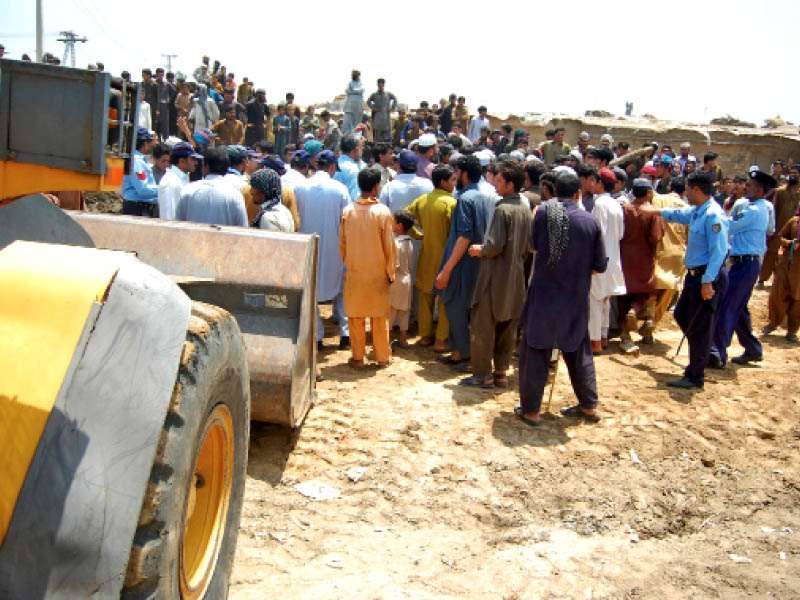 police officials try to convince the crowd that the bulldozers are not going to raze any house photo muhammad javaid