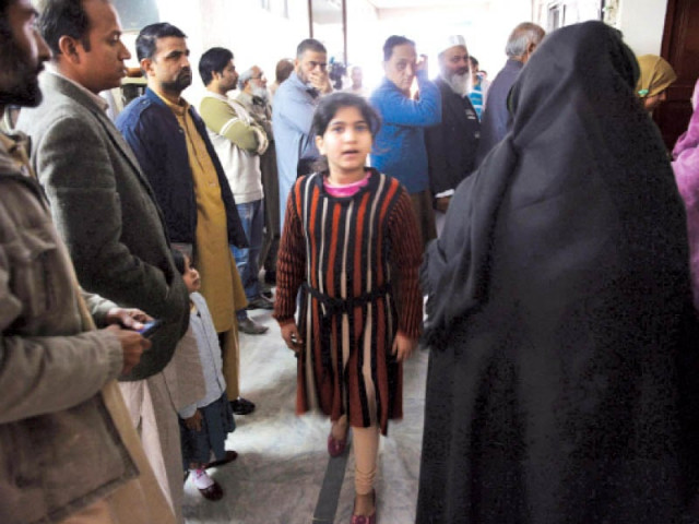 people queue up to collect amulets in rawalpindi photo afp
