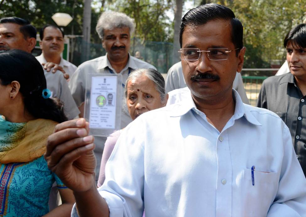 in this file photo arvind kejriwal r shows his voters card at a polling station in new delhi on april 10 2014 photo afp