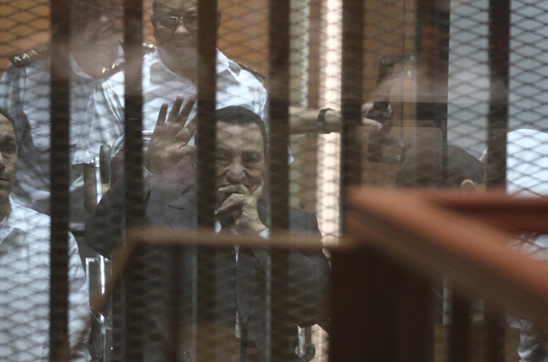 egypt 039 s deposed president hosni mubarak waves from behind the accused cage during his trial on may 21 2014 in cairo photo afp