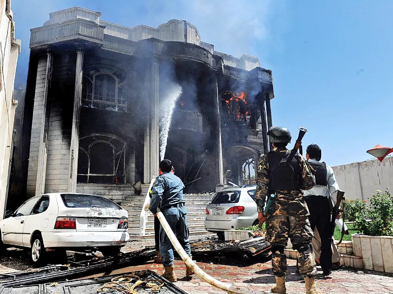 a policeman douses out flames following an attack on the indian consulate in herat photo afp a policeman douses out flames following an attack on the indian consulate in herat photo afp