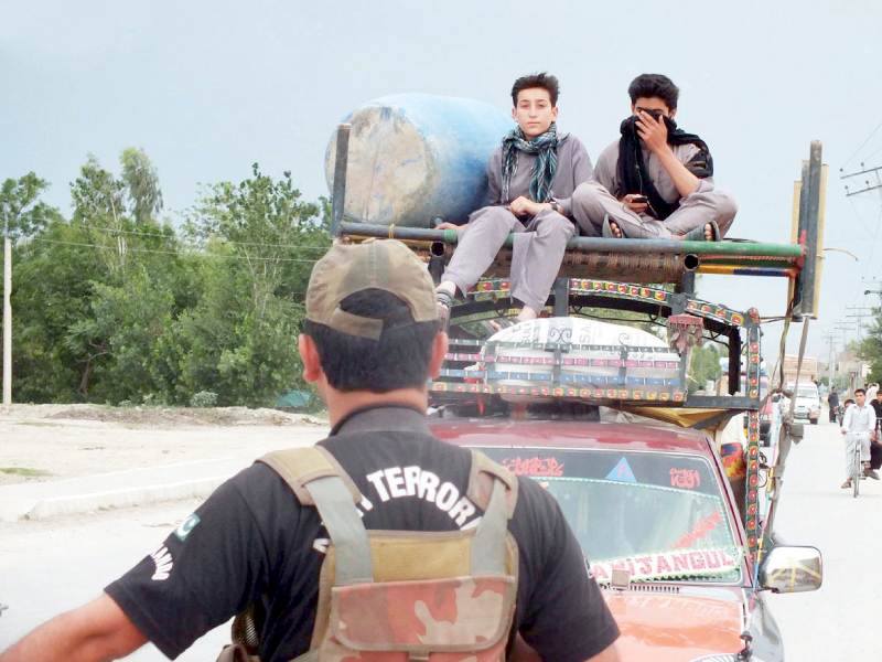 an official of security forces stops a vehicle carrying tribesmen from north waziristan agency at a checkpoint on miranmshah road photo online