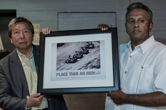 secretary general at amnesty international salil shetty r offers a reproduction of jeff widener 039 s tank man photo to lee cheuk yan hong kong lawmaker and chairman of the hong kong alliance in support of patriotic democratic movements in china during a tour of the june 4th museum in hong kong on may 28 2014 photo afp secretary general at amnesty international salil shetty r offers a reproduction of jeff widener 039 s tank man photo to lee cheuk yan hong kong lawmaker and chairman of the hong kong alliance in support of patriotic democratic movements in china during a tour of the june 4th museum in hong kong on may 28 2014 photo afp