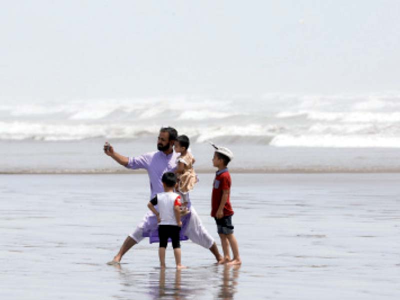 a man takes a selfie with his children at sea view beach on monday after the government lifted the lockdown that has been in place for almost five months photo reuters