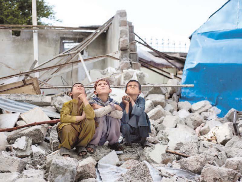 afghan children sitting on the remains of the pehli kiran school photo file express