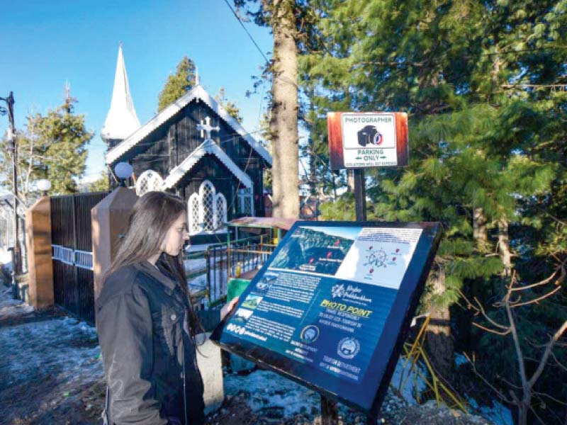 a visitor reads information about the church in galiyat at one of the many picture points set up by the galiyat development authority photo express