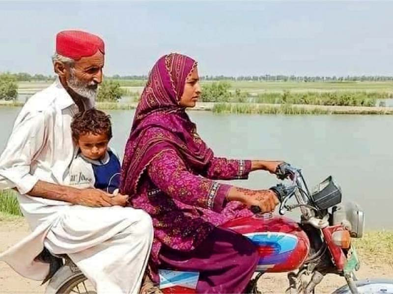 farzana shar takes her father to his workplace on a motorbike a woman riding a bike is a rare sight in rural areas photo express