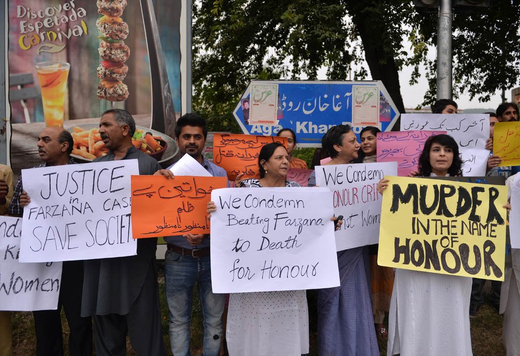 human rights activists hold placards as they chant slogans during a protest in islamabad on may 29 2014 against the killing of pregnant woman farzana iqbal photo afp