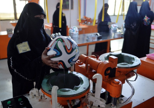 a worker applies adhesives to the edges of a design on a football ahead of the fifa world cup 2014 in brazil at a factory in sialkot photo afp a worker applies adhesives to the edges of a design on a football ahead of the fifa world cup 2014 in brazil at a factory in sialkot photo afp
