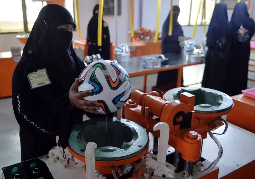a worker applies adhesives to the edges of a design on a football ahead of the fifa world cup 2014 in brazil at a factory in sialkot photo afp a worker applies adhesives to the edges of a design on a football ahead of the fifa world cup 2014 in brazil at a factory in sialkot photo afp
