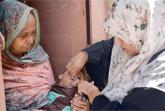 a health worker administers polio vaccine to a child in a karachi neighbourhood photo jalal qureshi express a health worker administers polio vaccine to a child in a karachi neighbourhood photo jalal qureshi express