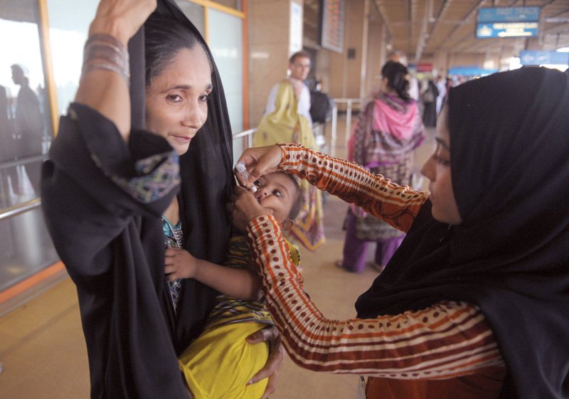 a pakistani health worker administers polio vaccine drops to a child at jinnah international airport in karachi all those travelling from the country will now have to get yellow polio certificates issued by the epi below in order to be allowed to travel photo file