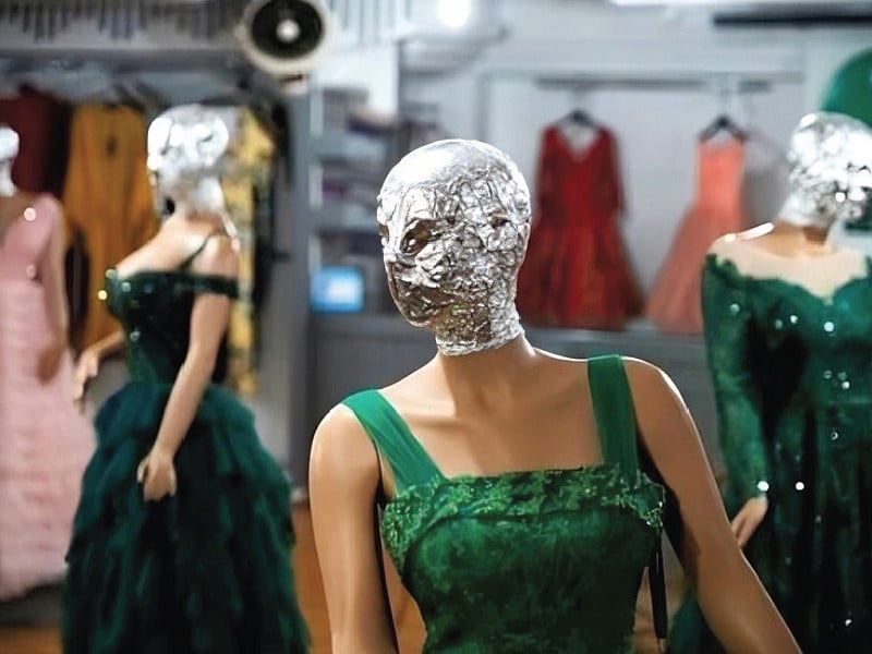 the heads of the mannequins sporting each dress are wrapped in plastic foil or black bags photo file