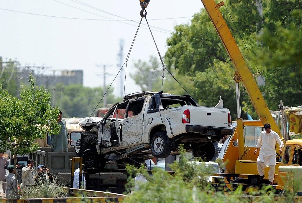 a damaged army vehicle is lifted with a crane at the site of a suicide bomb attack outside the town of fateh jang photo afp