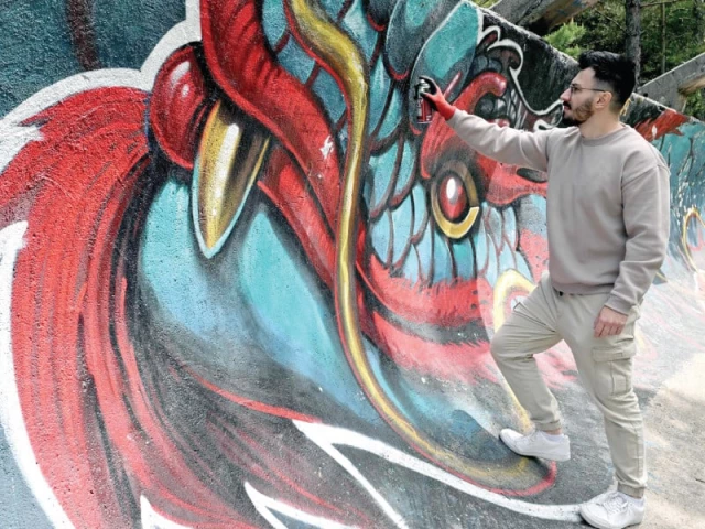 street artist kerim musanovic puts the finishing touches to a painting on the former olympic bobsled track near sarajevo photo afp
